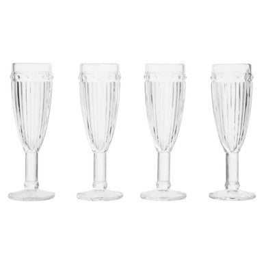 Set of four clear plastic champagne flutes on a white background