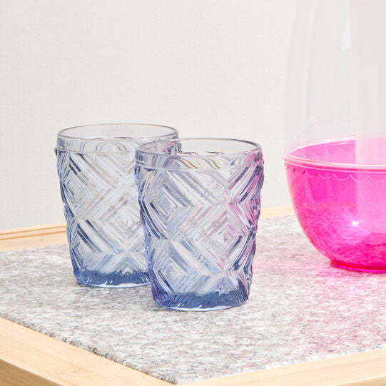Pink and clear glass pitcher with a pink bowl on a wooden surface.