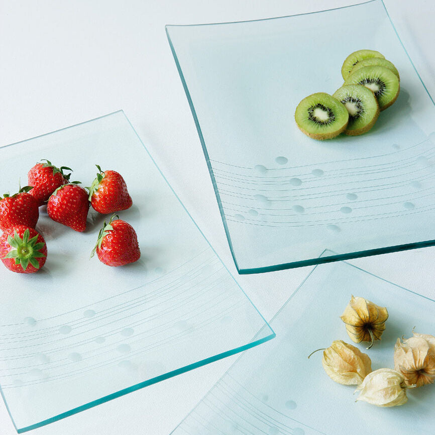 Glass plates with strawberries, kiwi slices, and physalis on a light background