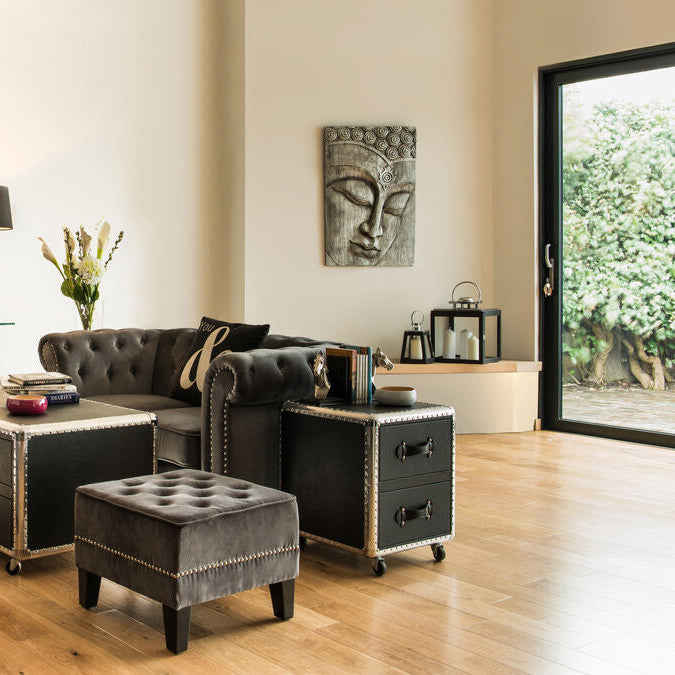 Modern living room with gray sofa, coffee table, and decorative items.