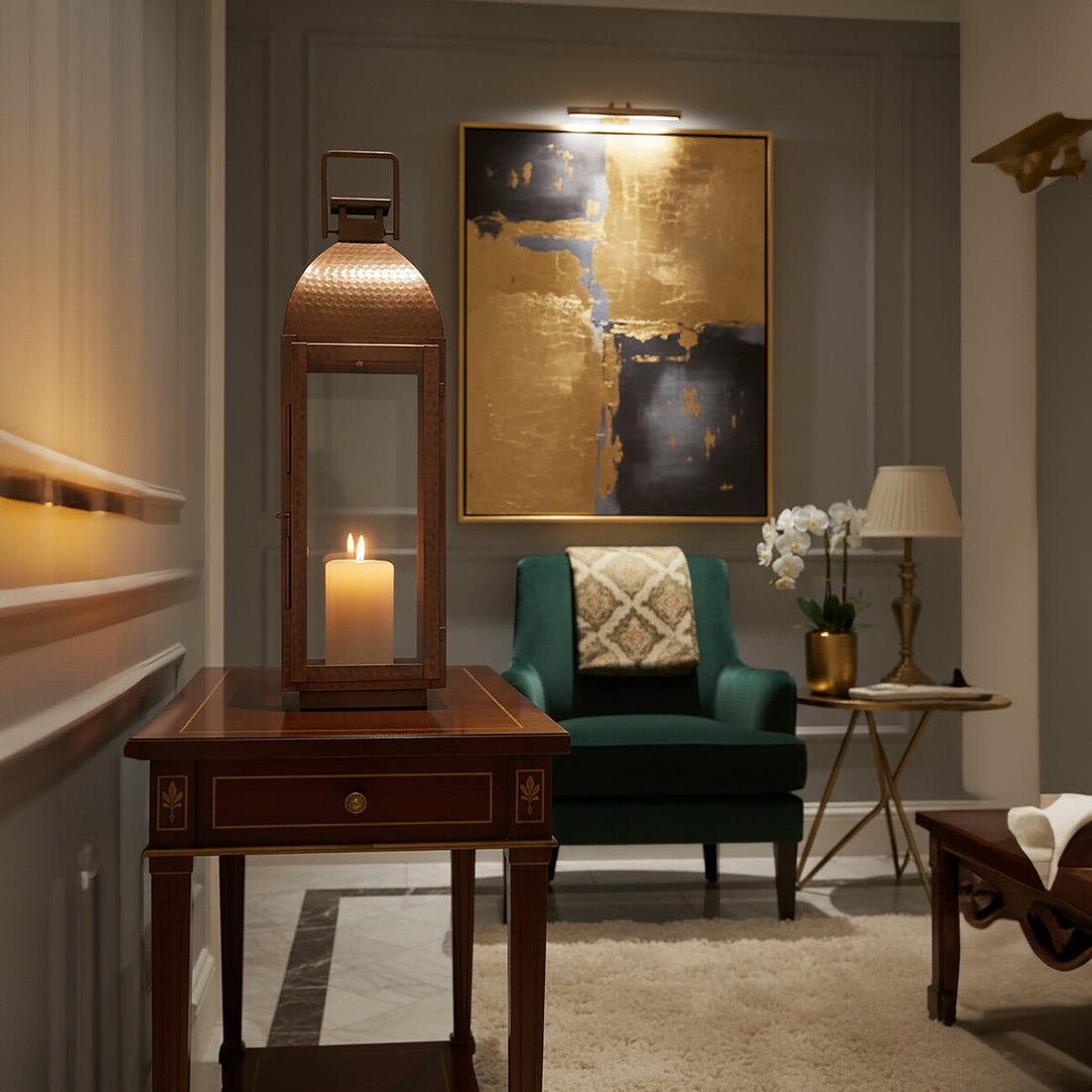 Decorative interior with a candlelit table, green armchair, and framed artwork.