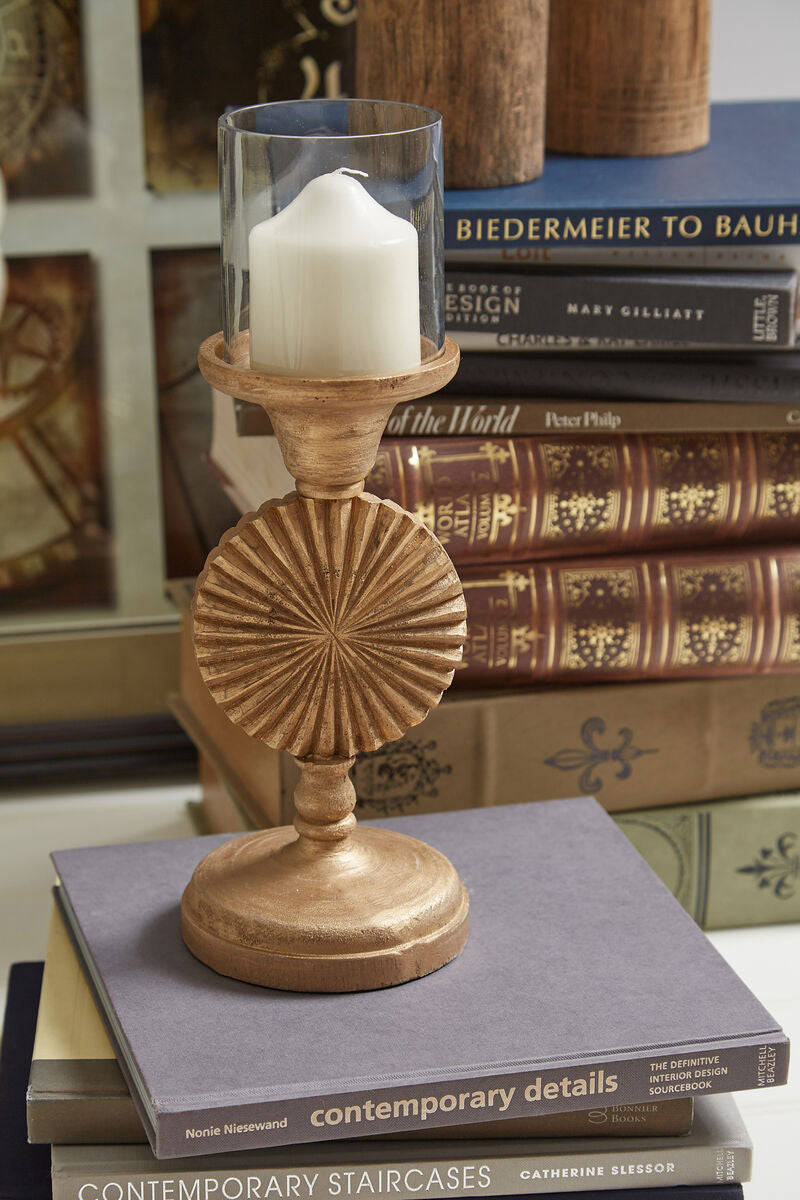 Decorative candle holder on a stack of books with a candle inside