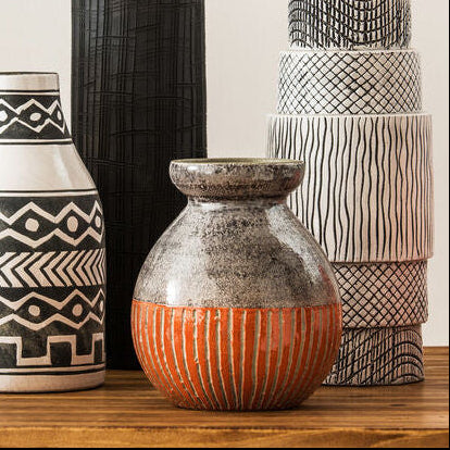 Collection of patterned vases on a wooden surface with a neutral background