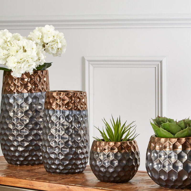 Set of three decorative vases with textured surfaces on a wooden surface.