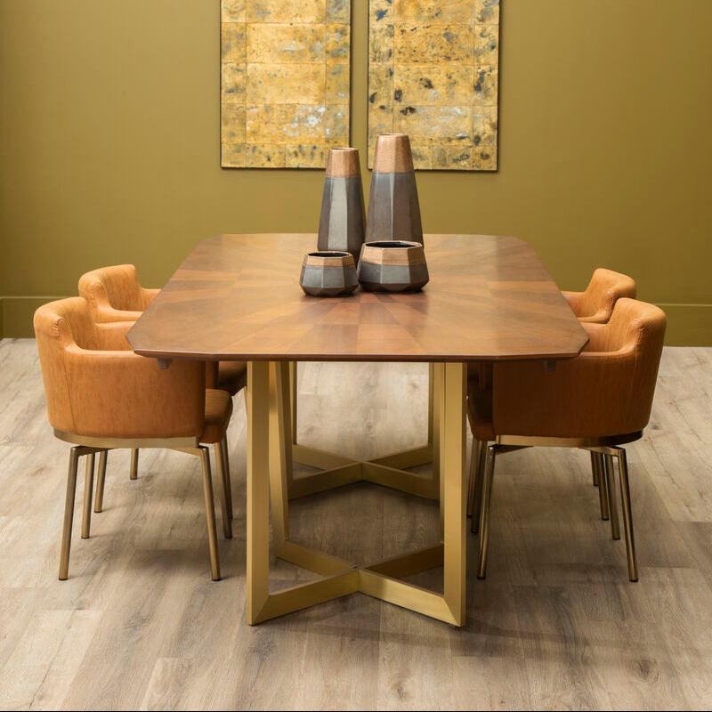 Dining room with wooden table, chairs, and decorative mirrors on a green wall.