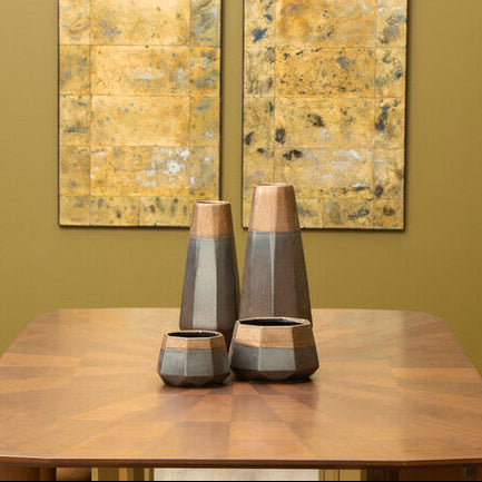 Dining room with wooden table, chairs, and decorative vases against a green wall.
