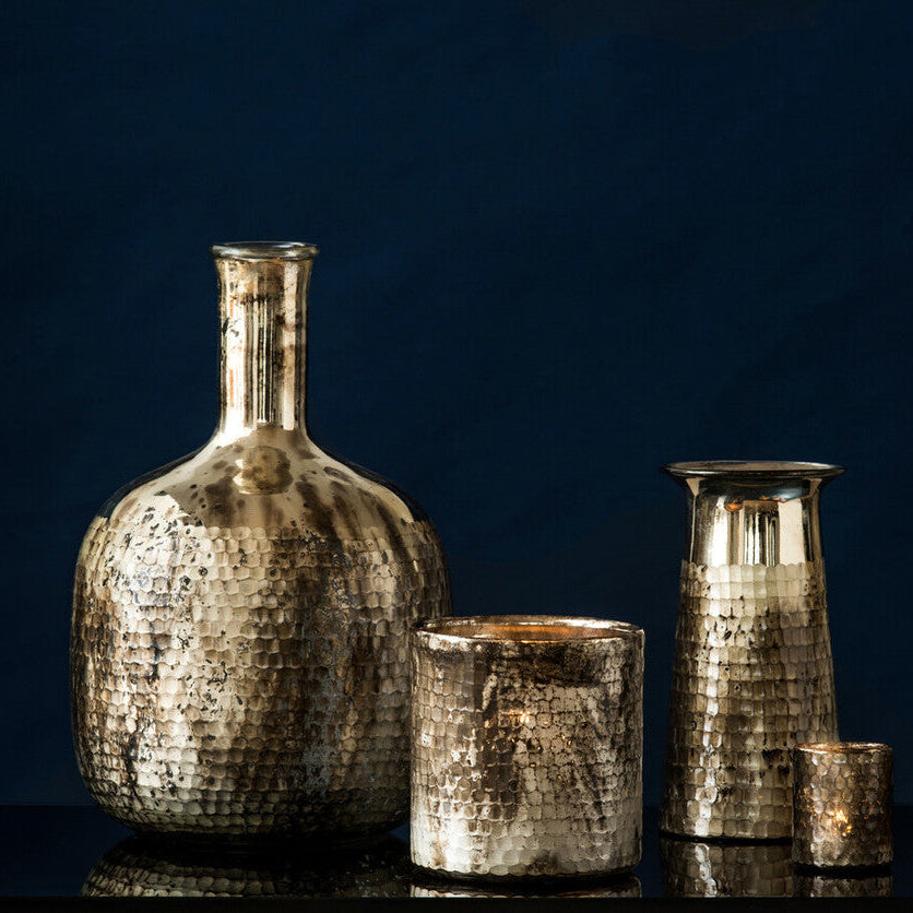 Set of metallic vases and candle holders on a dark background
