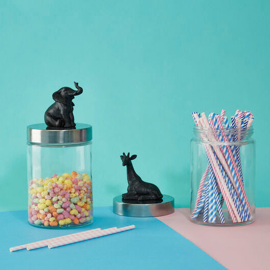 Two glass jars with animal figurines on a blue and pink background