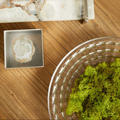 Metallic square containers with decorative elements on a wooden surface