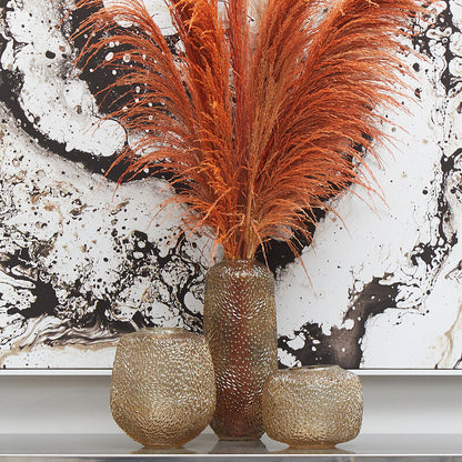 Decorative arrangement with orange feathers in a textured vase against a abstract art background