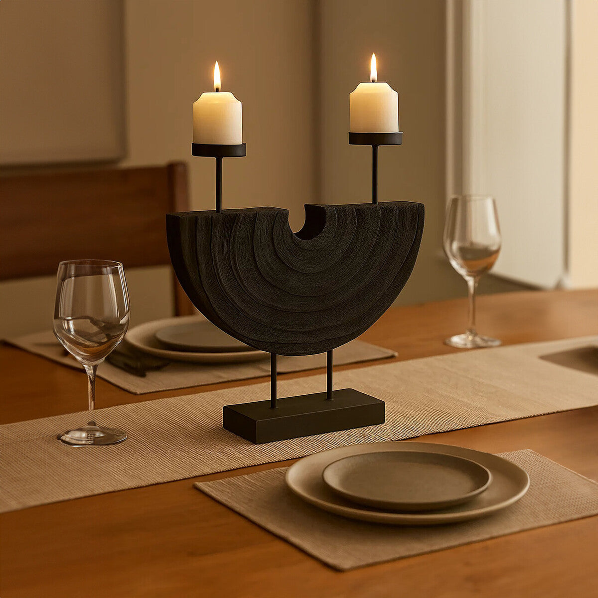 Decorative candle holder with two lit candles on a table setting.