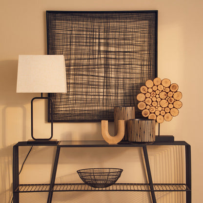 Modern black metal console table with decorative items against a beige wall.