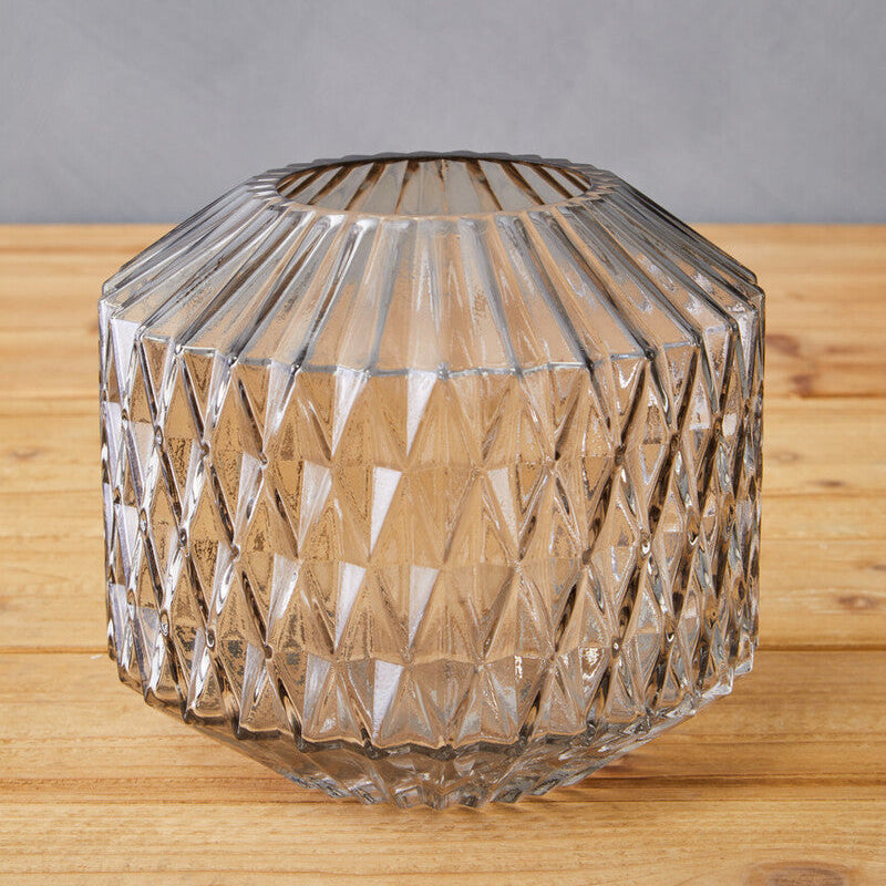 Clear glass vase with geometric pattern on a wooden surface