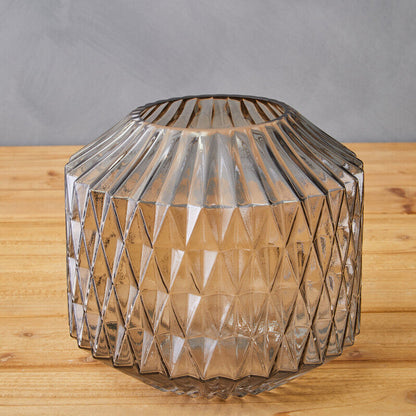 Clear glass vase with geometric pattern on a wooden surface