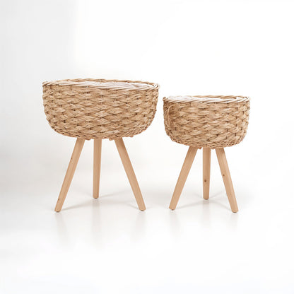Two woven baskets with wooden legs on a white background