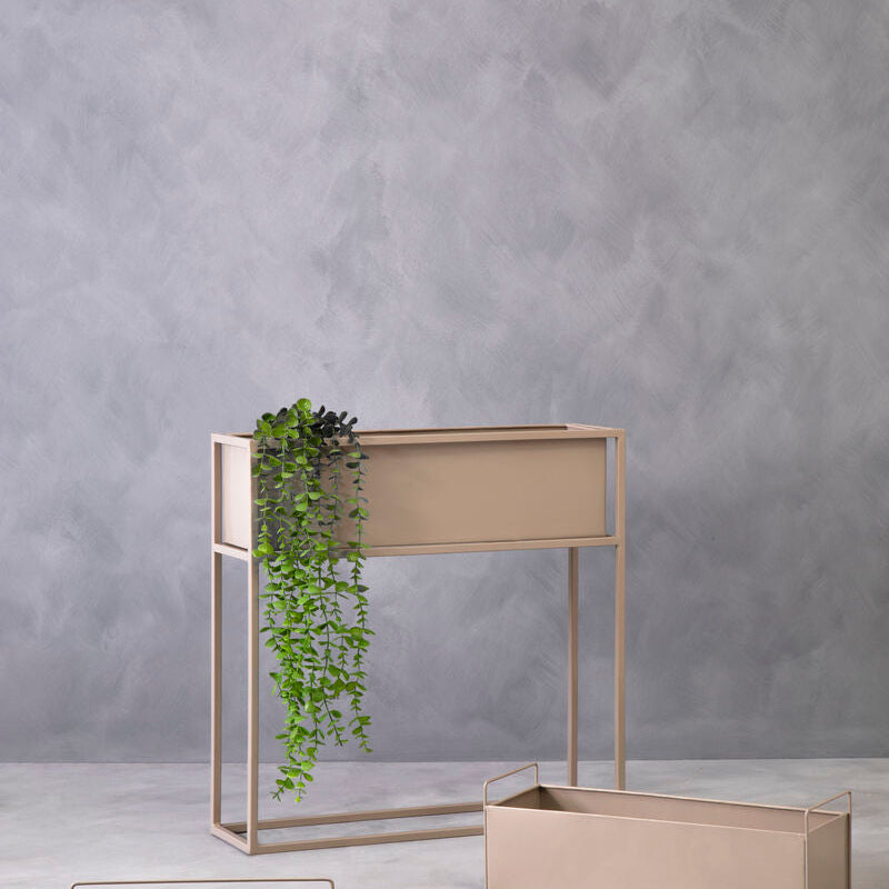 Set of beige metal planters against a gray wall