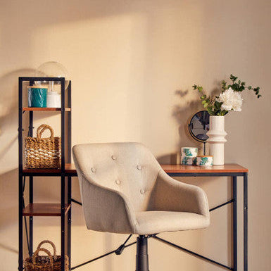 Beige office chair in a home office setting with a desk and shelves.