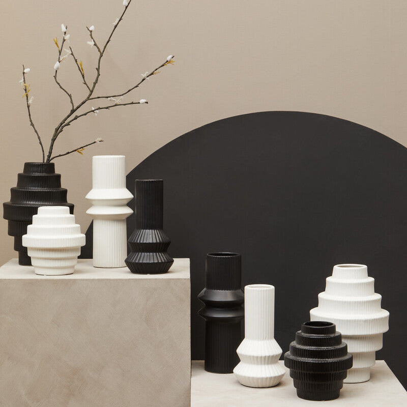 Collection of black and white vases on a neutral background