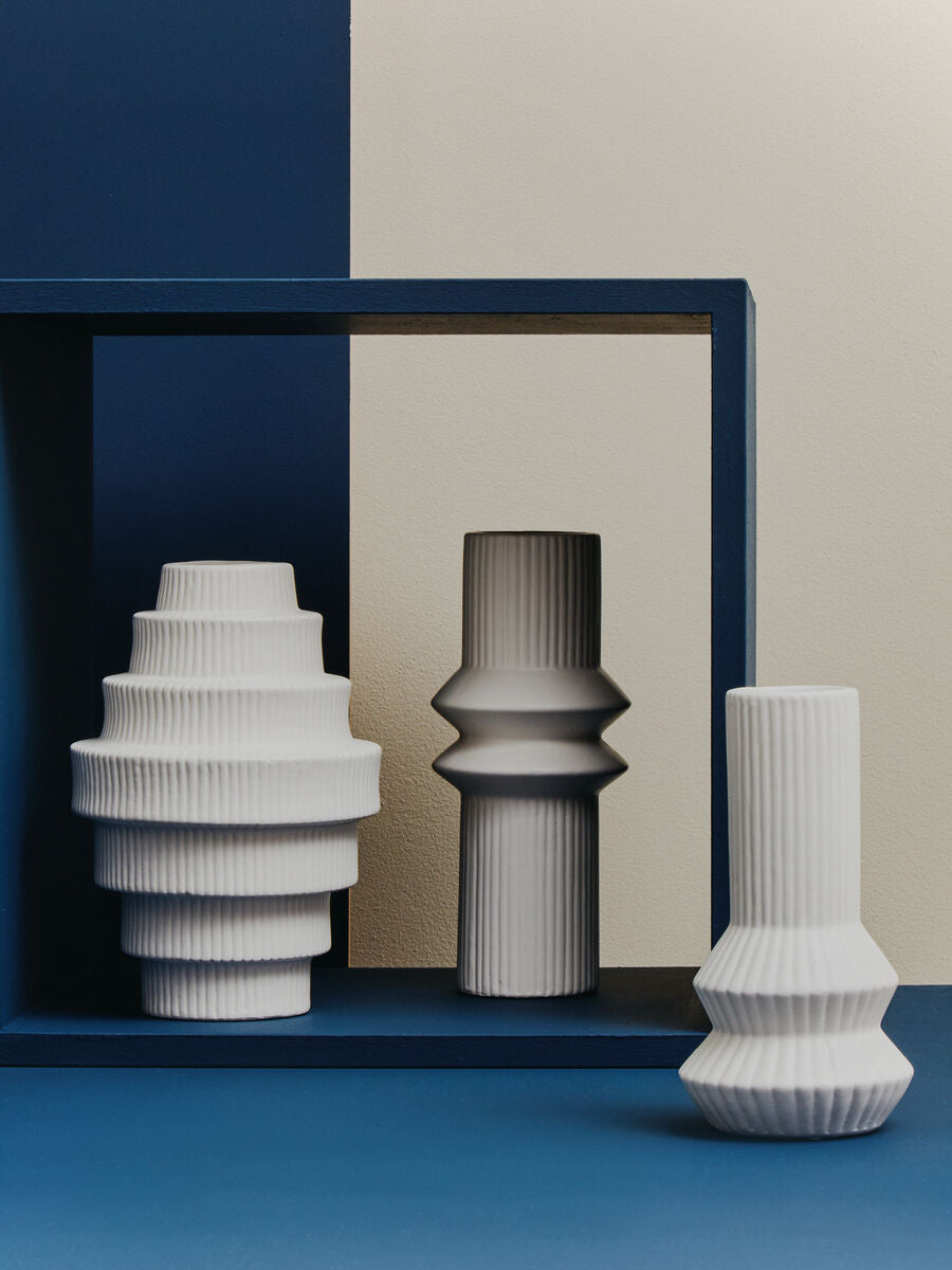 Three decorative vases on a blue and beige background