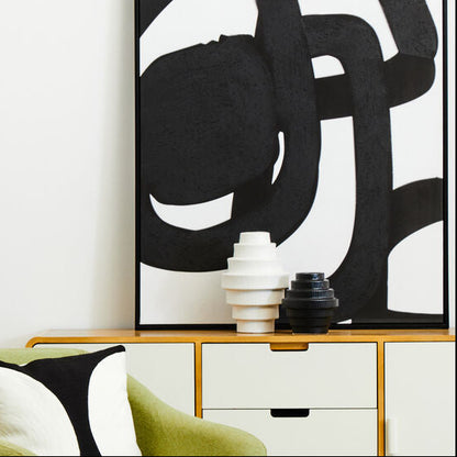 Modern interior with a green armchair, black floor lamp, and abstract artwork.