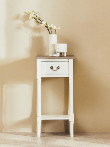 Small white side table with a wooden top against a beige wall.