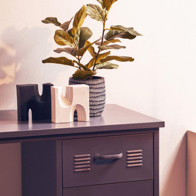 Purple metal locker with decorative items on a wooden surface
