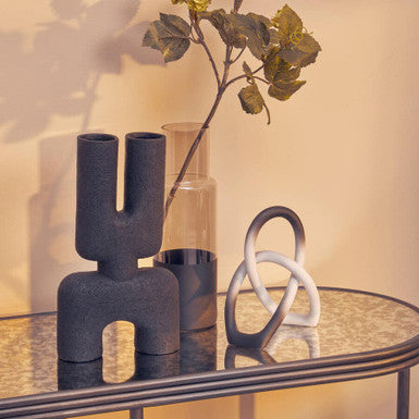 Decorative vases on a glass table with a warm background