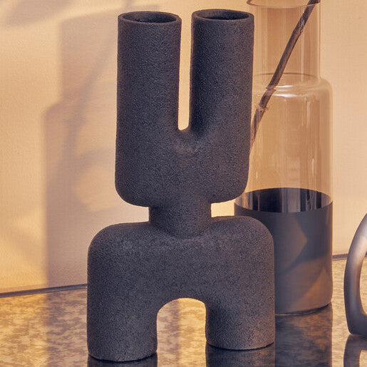 Decorative vases on a glass table with a warm background
