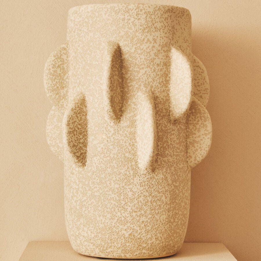 Textured vase with abstract design on a beige background