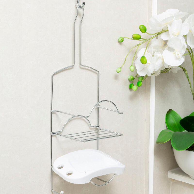 Metal shower caddy with soap holder hanging on a shower door next to a potted plant.