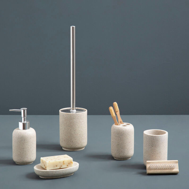 Set of bathroom accessories including a dispenser, brush holder, and soap dish on a gray surface with a dark gray background.