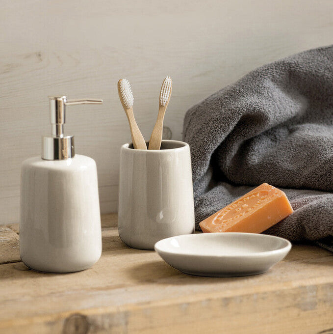 Napoleon Peugeot bathroom set with soap dispenser, toothbrush holder, and soap on a wooden surface.