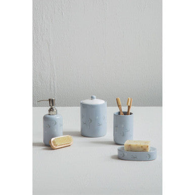 Set of blue ceramic bathroom accessories on a white surface with a light gray wall background.