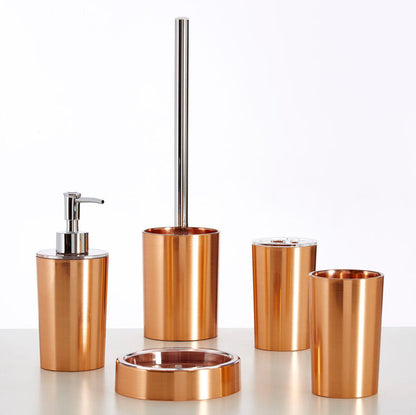 Set of bronze bathroom accessories including a dispenser, brush holder, and cups on a white background