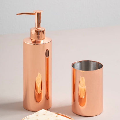 Copper bathroom accessory set with soap dish, dispenser, and cup on a light gray background