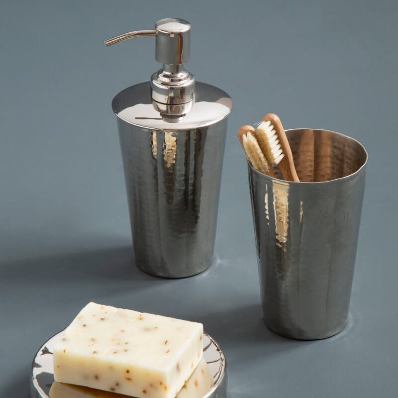 Bathroom accessories set with soap dispenser, toothbrush holder, and soap on a gray surface