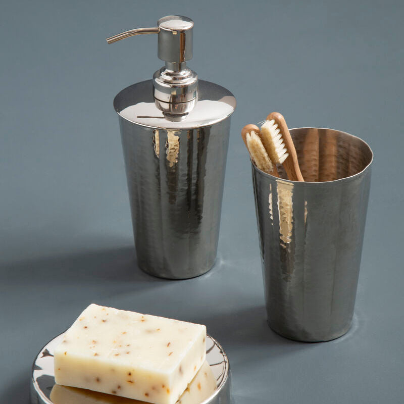 Bathroom accessories set with soap dispenser, toothbrush holder, and soap on a gray surface