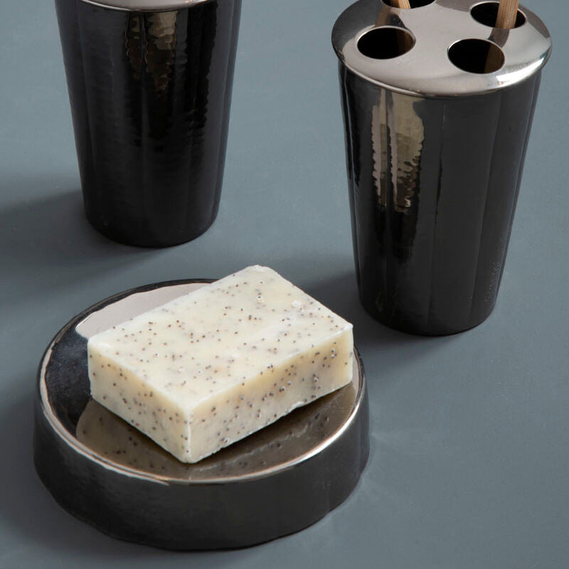 Bathroom accessory set with black soap dispenser, toothbrush holder, and soap dish on a gray background