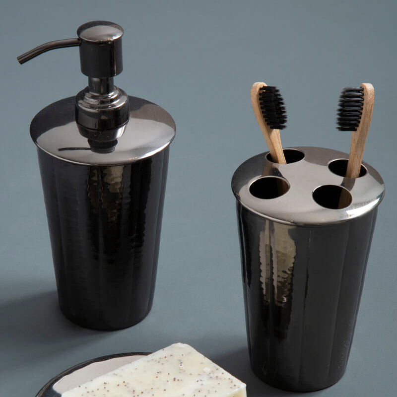 Black bathroom accessory set with soap dispenser, toothbrush holder, and soap dish on a gray background