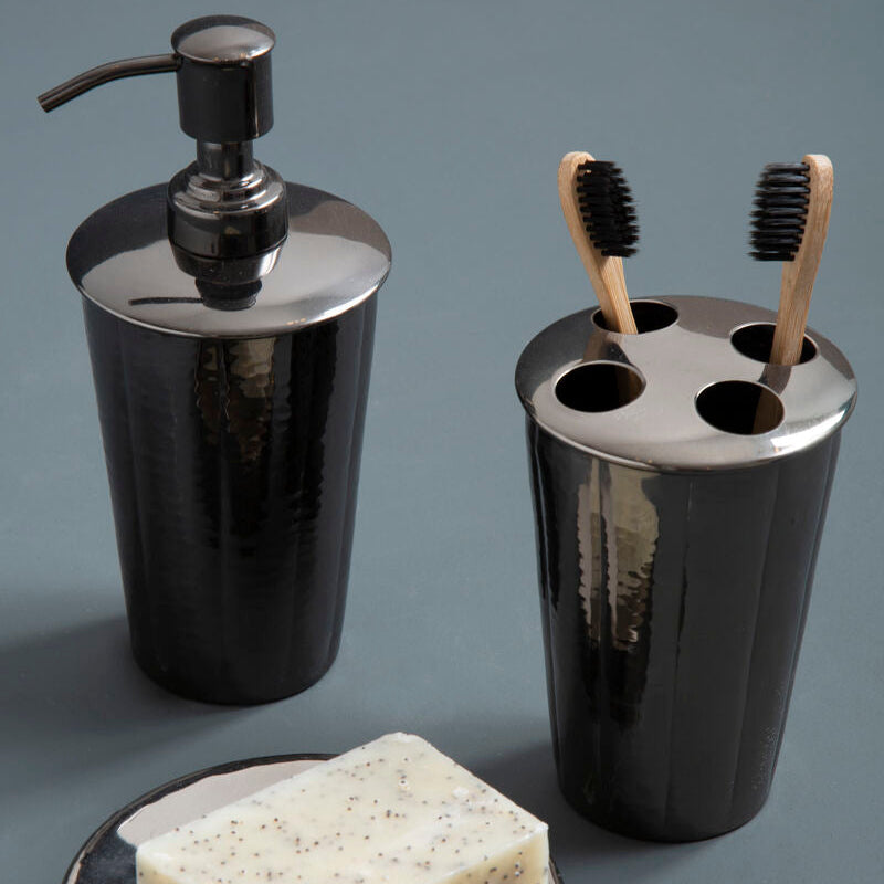 Black bathroom accessory set with soap dispenser, toothbrush holder, and soap dish on a gray background