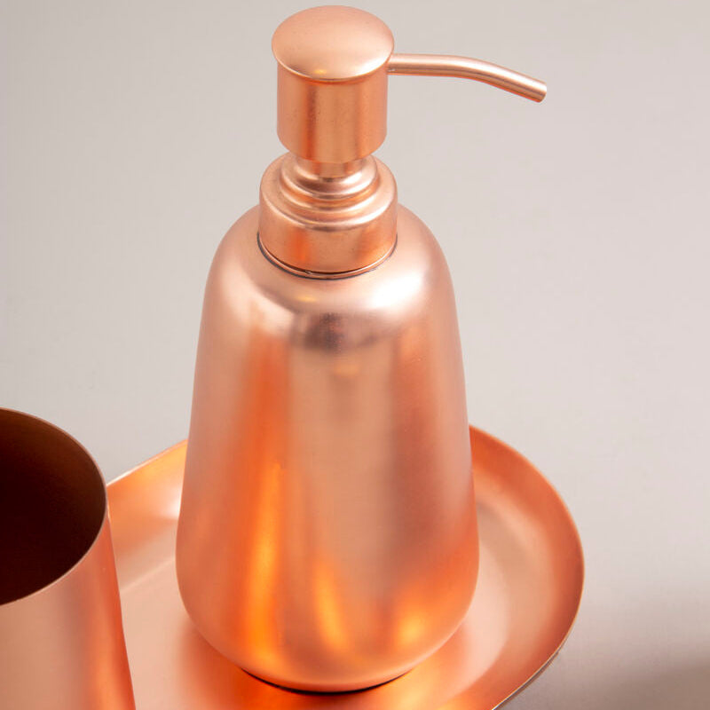 Rose gold soap dispenser on a matching tray with a neutral background