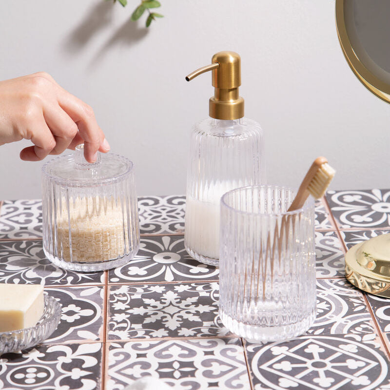 Clear glass containers with gold accents on a patterned surface