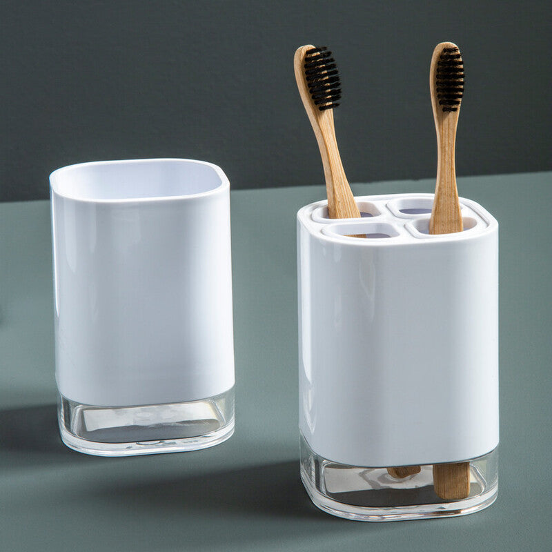 White toothbrush holder with bamboo toothbrushes on a gray surface