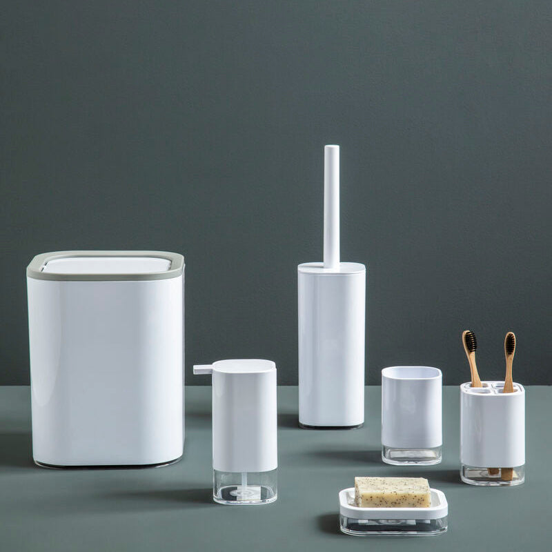 Set of bathroom accessories including a trash can, toilet brush holder, and other small containers on a dark surface with a gray background.