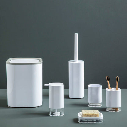Set of bathroom accessories including a trash can, toilet brush holder, and other small containers on a dark surface with a gray background.