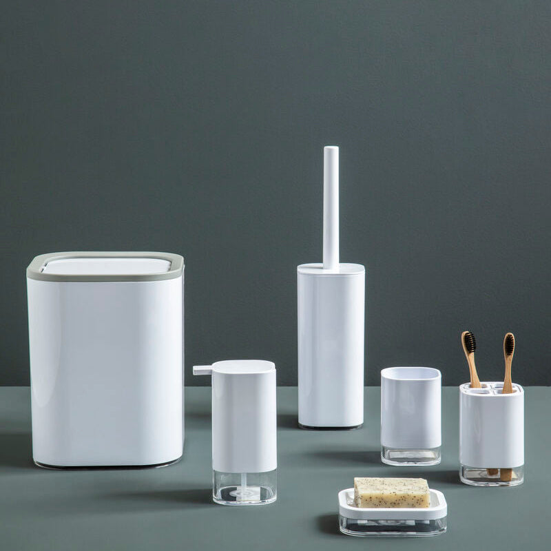 Set of bathroom accessories including a trash can, toilet brush holder, and other small containers on a dark surface with a gray background.