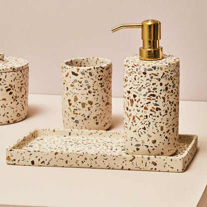 Terrazzo-patterned bathroom accessory set with a dispenser, cups, and tray on a neutral background