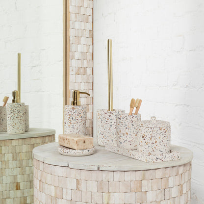 Bathroom setting with mosaic-tiled walls and a round vanity table with decorative items.