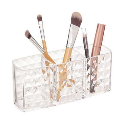 Clear acrylic makeup brush holder with various brushes on a white background