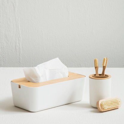 White tissue box with wooden tissue holder, toothbrush holder, and scrubber on a light surface.